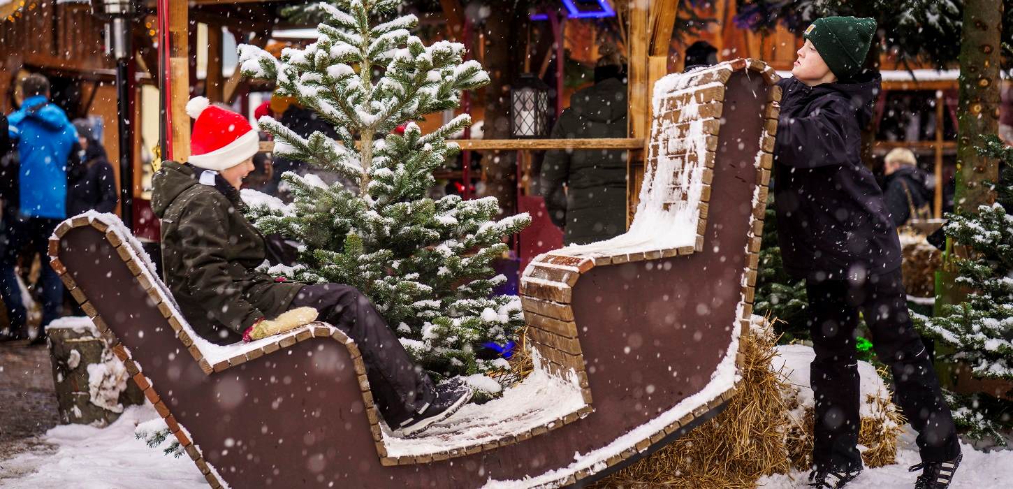 Børn leger i sneen til julemarkedet til jul i den gamle Kongeby