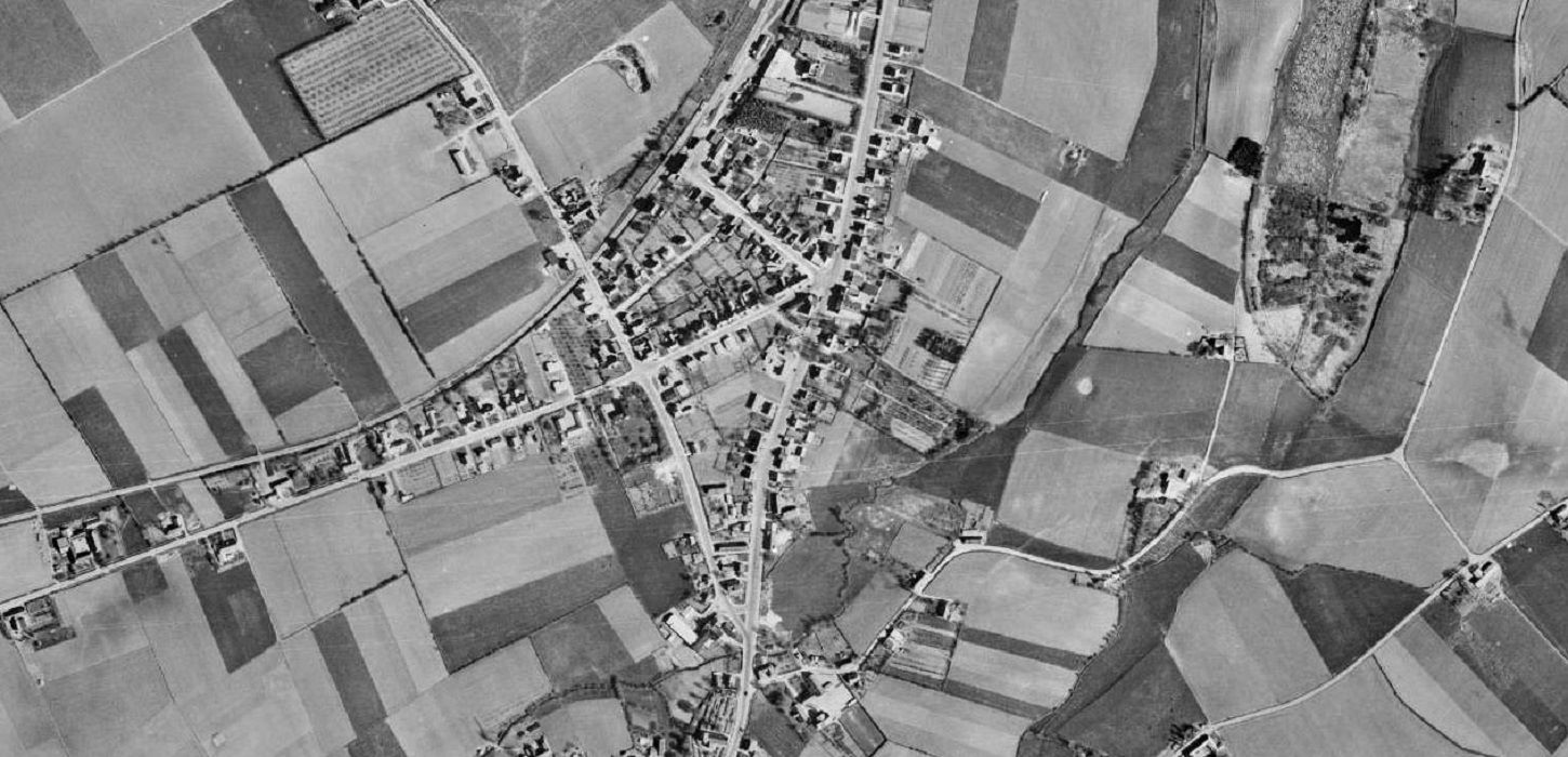 På luftfotografiet fra 1954 ses det tydeligt, hvordan bebyggelsen i Ørbæk følger vejenes forløb